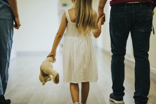 Image of a parent and the kid walking in the hallway 